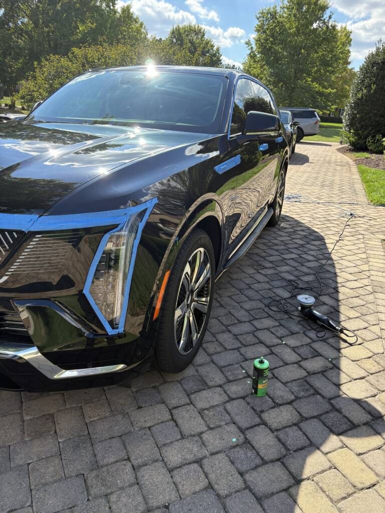 Black Cadillac reflecting the sky after detailing