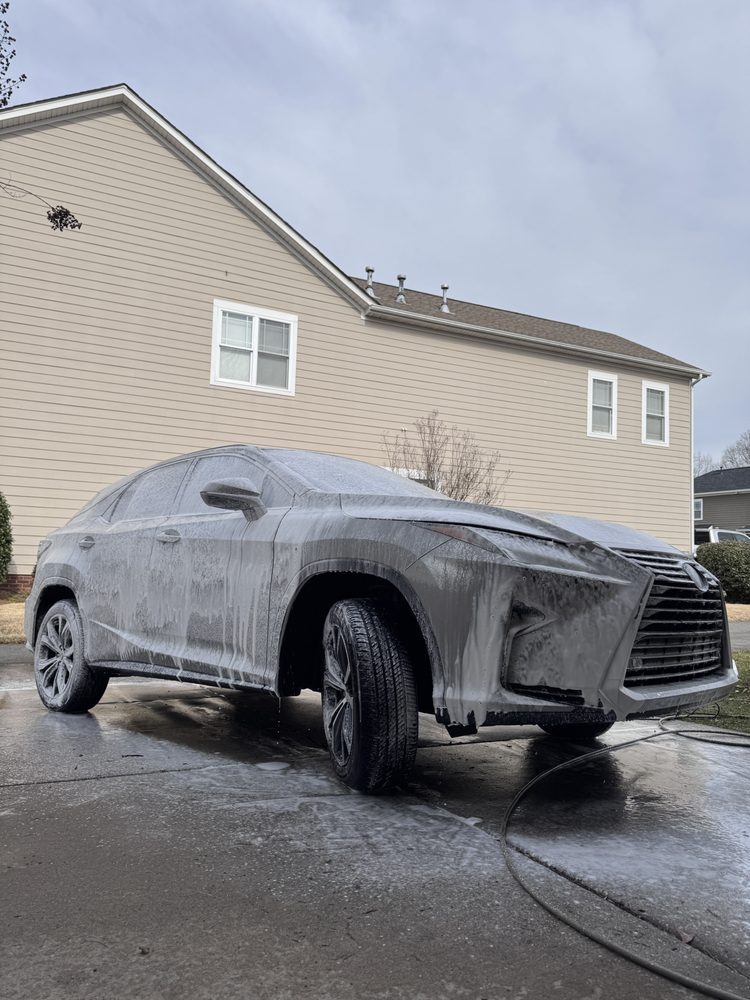 Foam pre-wash on a Lexus SUV in a customer driveway