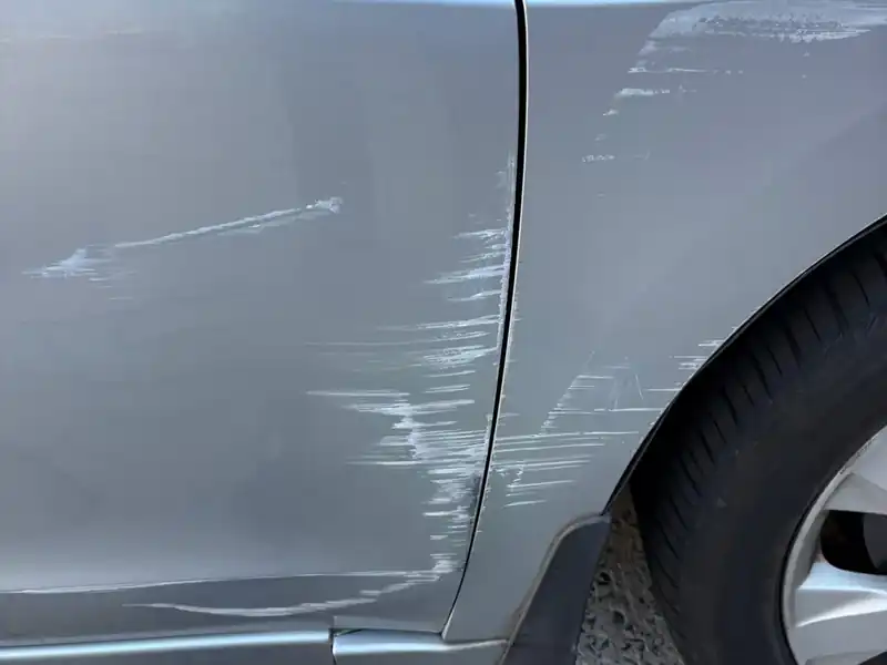 Paint transfer and scuffs on a silver Honda Accord door and fender