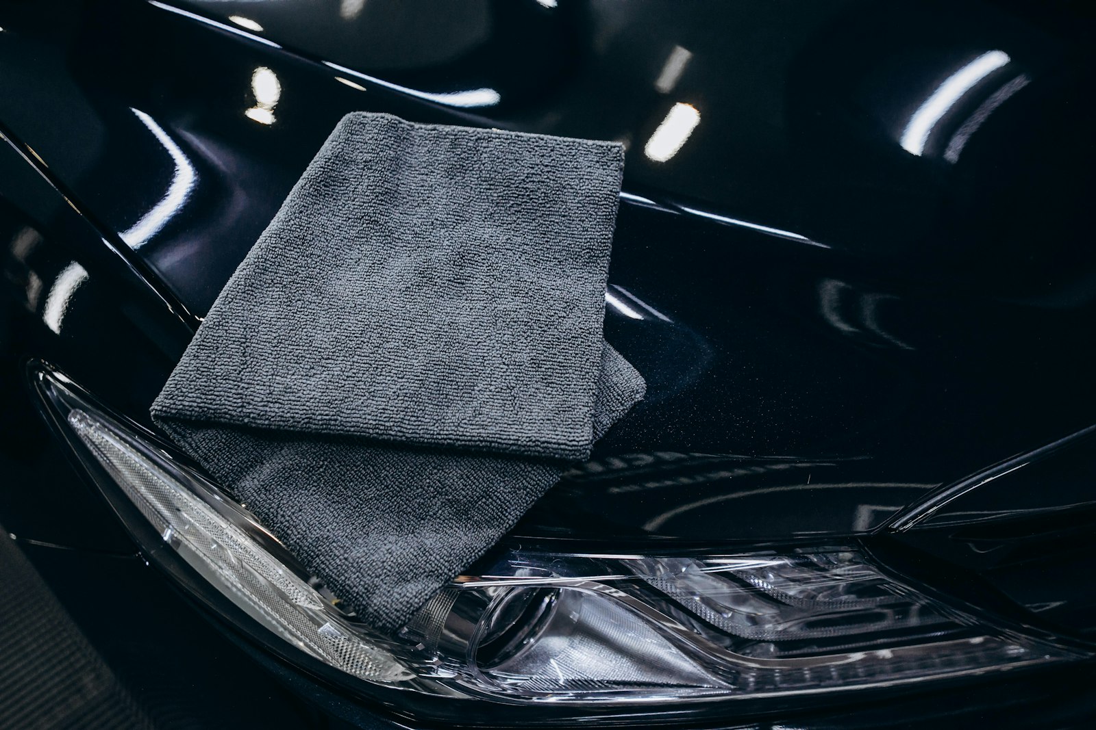 Clean gray microfiber towel on a black car hood